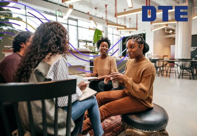 Diverse team collaborating in modern office space with DTE logo, discussing stakeholder engagement strategy